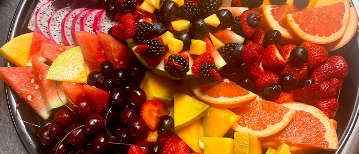Nick's Place catering serves delicious fruit platters, including cherries, watermelon, blackberries, and more.